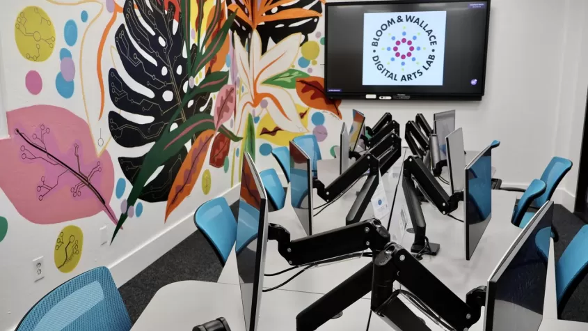 image of a computer lab with teal office chairs and colorful plants painted on the wall